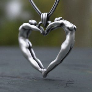 Handcrafted silver pendant depicting love through body shapes