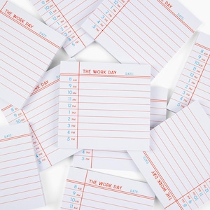 May include: A stack of white notepads with red and blue lines. Each notepad has the text "The Work Day" printed at the top and a space for the date. The notepads are designed for daily scheduling and task management.