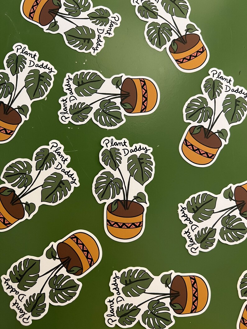 May include: Stickers featuring a potted Monstera plant with the text "Plant Daddy" in a handwritten font. The plant pot is brown with a tan and red geometric design. The background is a solid green.