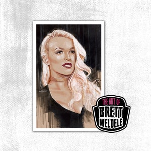 May include: A portrait print featuring a woman with long, wavy blonde hair, red lipstick, and a gold choker. The artwork is signed and includes the text "THE ART OF BRETT WELDELE" in a black and white logo.