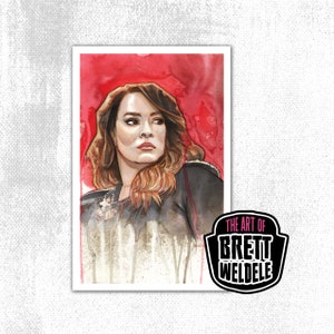 May include: Watercolor portrait of a woman with brown hair and a serious expression, set against a red background. The artwork is signed with the text "THE ART OF BRETT WELDELE" in a black and white logo.