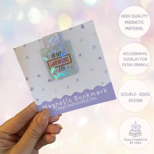 Könnte beinhalten: Magnetischer Lesezeichen mit holografischer Beschichtung. Das Lesezeichen zeigt den Text "IN MY SHOWGIRL ERA" in einem rot-weißen Design. Das Lesezeichen befindet sich auf einer weißen Karte mit dem Text "Magnetic Bookmark CosyCreationsByChes".