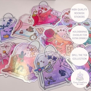 May include: A selection of vibrant, book-themed stickers shaped like teabags. Each sticker showcases distinct illustrations, such as a cowboy boot, a rose, and a dragon. The stickers have a holographic finish and are part of the "Spill The Tea Collection."