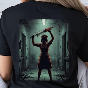 Peut inclure: Un t-shirt noir avec une impression graphique au dos. L'illustration représente la silhouette d'une infirmière en uniforme et coiffe, debout dans un couloir d'hôpital sombre et délabré, tenant une grande seringue au-dessus avec des gouttes rouges.