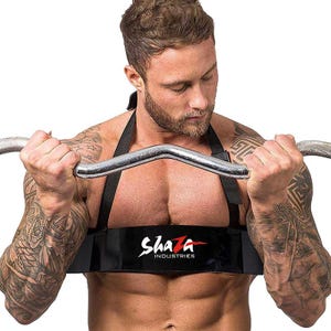 May include: Black weightlifting arm blaster with the text "Shaza Industries" in white and red. The arm blaster is worn around the upper arms and chest, and is used to isolate the biceps during weightlifting exercises.