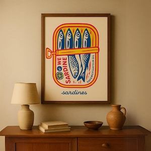 Printable sardine poster designed for rustic beach cottage interiors, a thoughtful gift for her or ocean lovers.
May include: A framed print of a vintage-style illustration of a can of sardines. The can is yellow with red and blue accents. The text on the can reads 'We Sardine Sardine Fillets in Oil' and 'sardines'. The background of the print is cream colored.