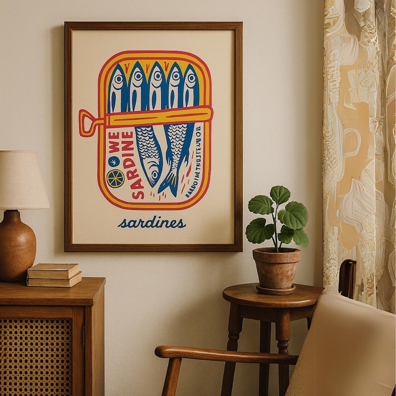 Print sardines digital wall art Print fish retro decor Print kitchen home wall art Gift housewarming home decor Gift for her ocean theme. May include: A vintage-style illustration of a can of sardines. The can is yellow with red and blue accents. The can says 'We Sardine' and 'Sardines in Olive Oil' in a retro font. The illustration is printed on a white background and framed in a brown frame.