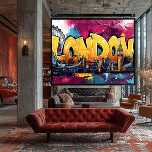 Könnte beinhalten: Ein großer, farbenfroher Leinwanddruck mit dem Wort "LONDON" in gelbem Graffiti-Stil. Das Kunstwerk zeigt berühmte Londoner Wahrzeichen wie die Tower Bridge und Big Ben vor einem lebendigen, abstrakten Hintergrund mit Rosa-, Blau- und Lilatönen.