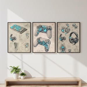 Könnte beinhalten: Drei gerahmte Drucke mit Illustrationen zum Thema Gaming. Ein Druck zeigt eine Tastatur und ein Headset, ein weiterer zeigt zwei Gamecontroller und der dritte hebt verschiedene Headsets hervor. Jedes Design enthält blaue Leuchtakzente.