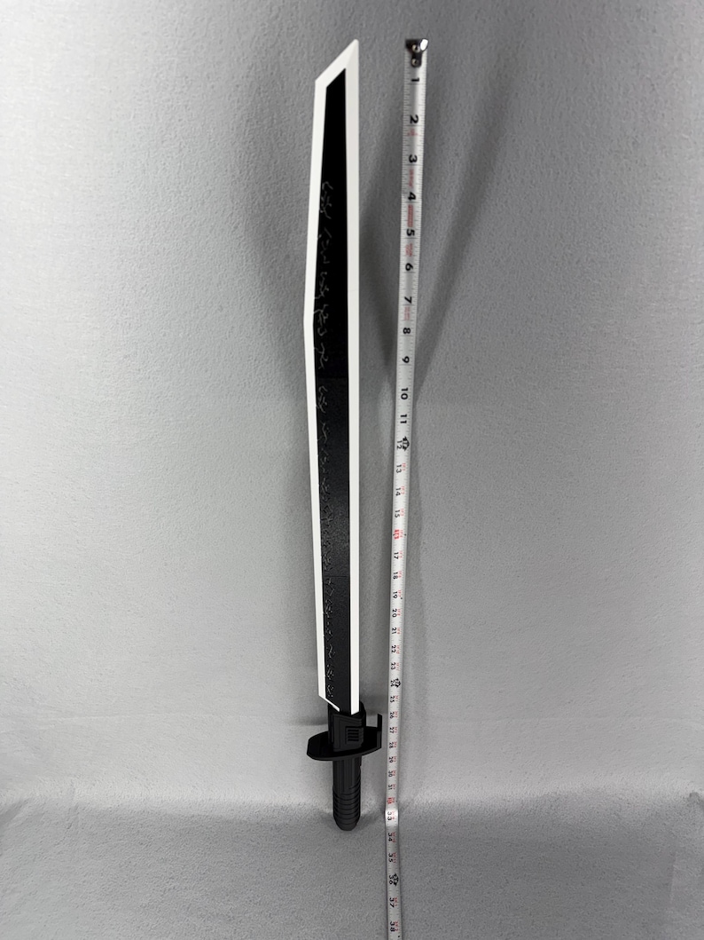 May include: A black and white decorative sword with a straight blade. The sword is approximately 36 inches long. The blade has a black surface with white edges and a white stripe down the center. The handle is black.