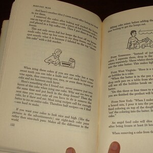 Puede incluir: Un primer plano de un libro abierto con ilustraciones en blanco y negro. El libro se titula "Bake-Off Blues" y contiene consejos para hornear pasteles. El texto incluye consejos sobre c&oacute;mo glasear pasteles, eliminar las burbujas de la masa para pasteles y crear un pastel de m&aacute;rmol.