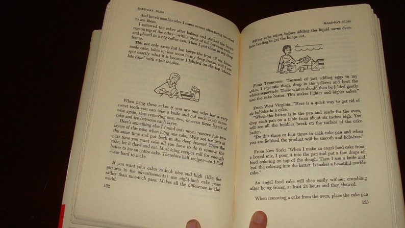 Puede incluir: Un primer plano de un libro abierto con ilustraciones en blanco y negro. El libro se titula "Bake-Off Blues" y contiene consejos para hornear pasteles. El texto incluye consejos sobre c&oacute;mo glasear pasteles, eliminar las burbujas de la masa para pasteles y crear un pastel de m&aacute;rmol.