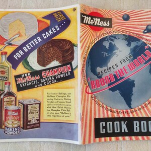 May include: A vintage cookbook cover featuring a globe illustration in red, white, and blue with the text "Recipes from Around the World". The cover also has a yellow and orange sunburst design with the text "McNess" in a red circle.
