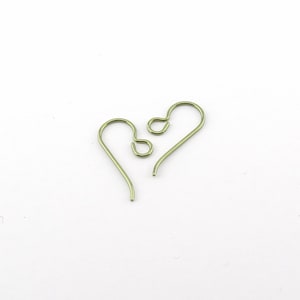 May include: Two pairs of light green, heart-shaped earring hooks are displayed against a white background. The hooks are made of thin wire and have a simple, minimalist design. The earrings are suitable for jewelry making.