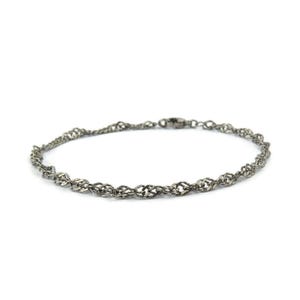 Könnte beinhalten: Ein silberfarbenes Armband mit einem filigranen, gedrehten Seildesign. Das Armband hat einen kleinen Verschluss und wird vor einem weißen Hintergrund präsentiert. Das Schmuckstück ist ein schlichtes, elegantes Accessoire.