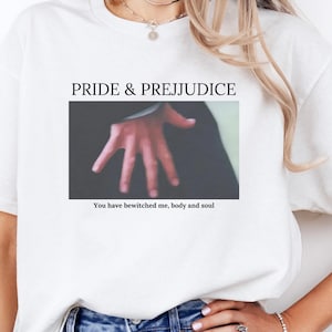 May include: White t-shirt with the text "PRIDE & PREJUDICE" and an image of a hand. The text "You have bewitched me, body and soul" is below the image. The word "WHITE" is printed in large black letters in the upper left corner of the shirt.