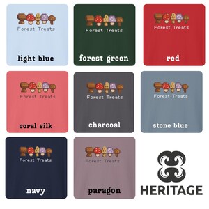 May include: Nine square images showcasing t-shirts in various colors, each featuring a pixelated mushroom design and the text "Forest Treats." Colors include light blue, forest green, red, coral silk, charcoal, stone blue, navy, and paragon.