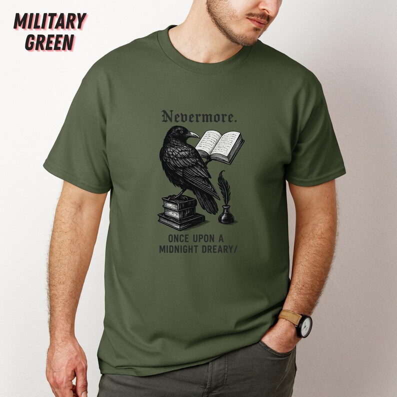 May include: Military green t-shirt featuring a black raven illustration with the text "Nevermore" and "Once Upon a Midnight Dreary." The raven is perched on books, holding an open book. A quill and inkwell are also depicted.