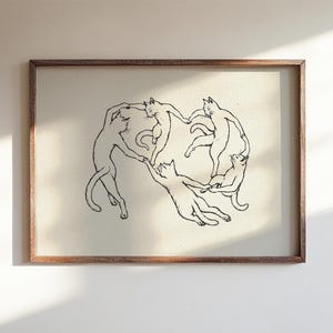 Physical matte paper art print featuring five hand drawn minimalist line art cats dancing in a circle, a funny modern cat poster parody inspired by Matisse. Black and white unframed sketchy pet print for girl apartment decor, scandi style wall art, and cozy bedroom layouts.