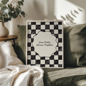 Funny "Save Water, Shower Together" bathroom wall art featuring a hand-drawn red and cream checkered pattern in a retro indie aesthetic.