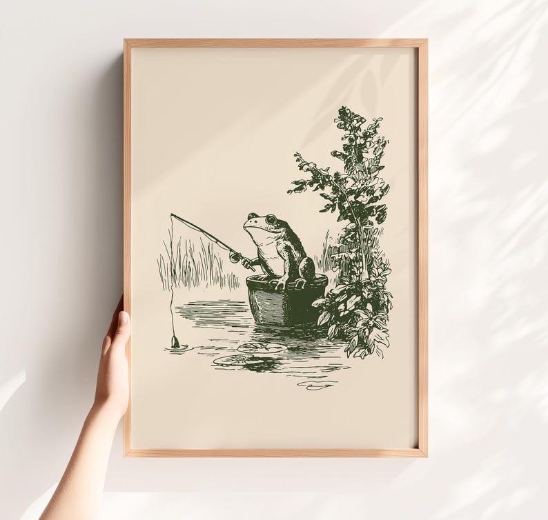 Hand drawn poster of a fishing frog sitting in a bucket by the water, ink drawing with vintage line art style, frog wall art for lake house decor, cabin decor, and fishing wall art.