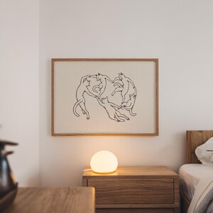 Physical matte paper art print featuring five hand drawn minimalist line art cats dancing in a circle, a funny modern cat poster parody inspired by Matisse. Black and white unframed sketchy pet print for girl apartment decor, scandi style wall art, and cozy bedroom layouts.