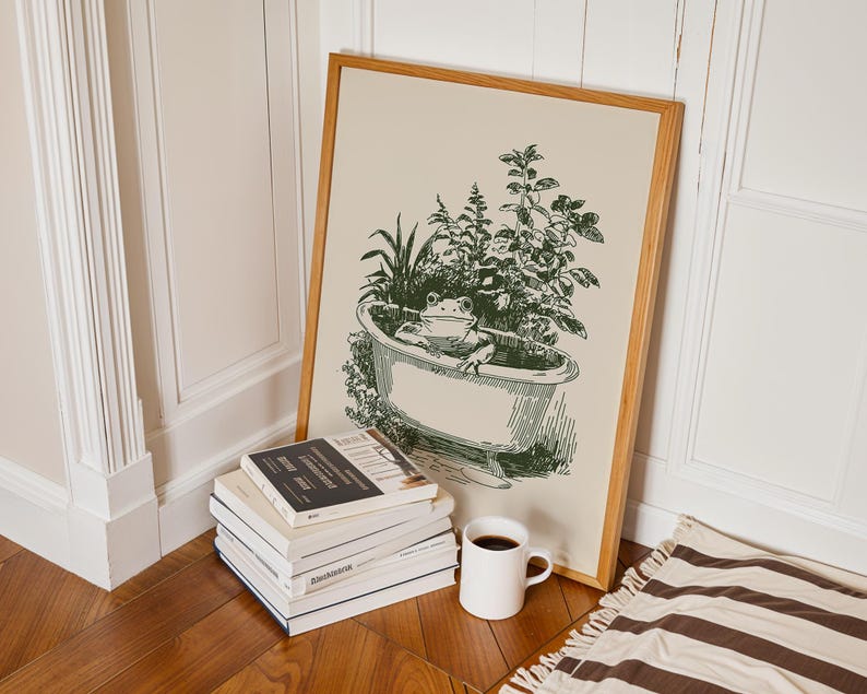 Ink-style drawing of a frog relaxing in a bathtub surrounded by leafy plants, with a soft vintage cottagecore look. Neutral simple art for guest bathroom decor.