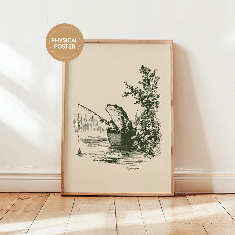 Hand drawn poster of a fishing frog sitting in a bucket by the water, ink drawing with vintage line art style, frog wall art for lake house decor, cabin decor, and fishing wall art.