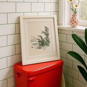Hand drawn poster of a fishing frog sitting in a bucket by the water, ink drawing with vintage line art style, frog wall art for lake house decor, cabin decor, and fishing wall art.