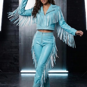 May include: A turquoise leather cowgirl outfit, including a jacket, pants, boots, and hat. The jacket and pants feature long white fringe. The hat and boots have decorative stitching. The outfit is a matching set.