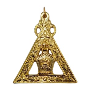 May include: A gold-colored pendant featuring a triangle design with ornate detailing. The pendant has a central emblem and a loop for hanging. The overall design is symmetrical and detailed, with a polished finish.
