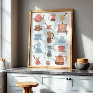 May include: A framed print with watercolour illustrations of teapots, coffee pots, and cups in shades of red, brown, blue, and yellow. The artwork is displayed on a white cabinet with a wooden stool, next to a window.