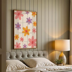 May include: A framed floral art print featuring a cream background with colorful flowers in pink, orange, and purple. The flowers are stylized with brushstroke details. The artwork is displayed above a bed with a gray tufted headboard.