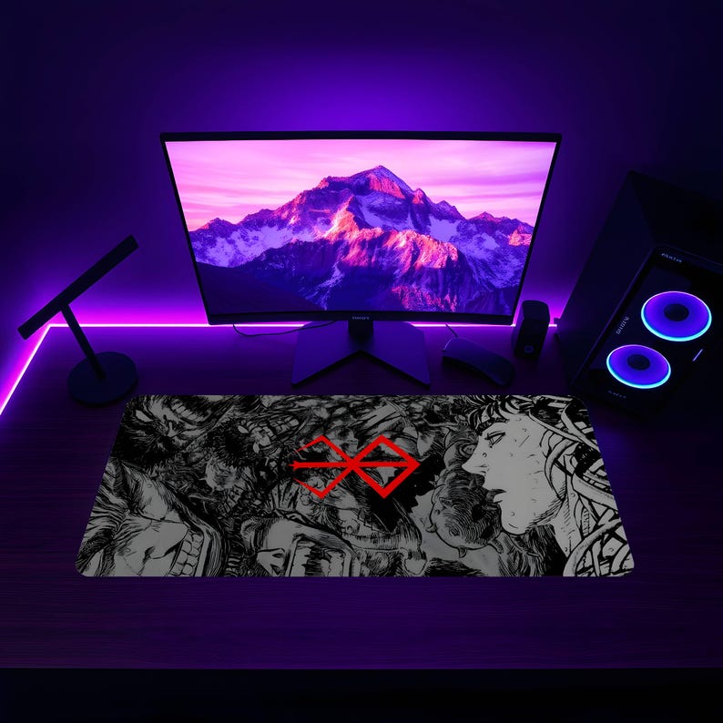 May include: A black and white graphic design mousepad with a red symbol in the center. The symbol is a stylized cross with a circle around it. The mousepad is on a desk with a computer monitor and speakers.