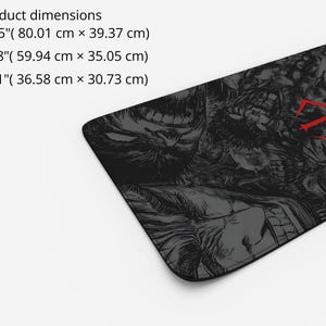 May include: A black and gray mousepad with a graphic print of a skull and a red symbol. The mousepad is available in three sizes: 31.5 inches by 15.5 inches, 23.6 inches by 13.8 inches, and 14.4 inches by 12.1 inches.