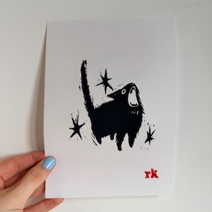 May include: Black and white art print featuring a stylized black cat with an open mouth, surrounded by star shapes. The cat has a textured appearance. The artist's initials, "rk", are in red in the lower right corner.