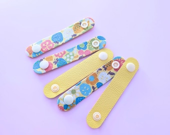 Juego de 5 soportes reversibles de tela y cuero con cierre a presión, para cables.