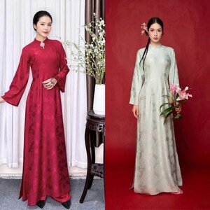 Könnte beinhalten: Zwei Frauen in traditionellen langen Kleidern. Eines ist tiefrot mit floralem Muster, das andere hellgrün mit ähnlichem Design. Beide Kleider haben lange Ärmel und Stehkragen. Der Hintergrund ist eine Mischung aus Rot und neutralen Tönen.