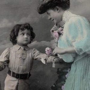 Postal francesa antigua de 1911: Una bella madre eduardiana con un largo vestido azul se alegra de la llegada de su hijo en barco.