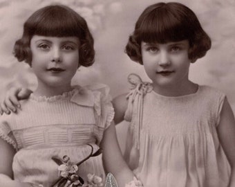 1920er Jahre Zwei kleine Mädchen vielleicht Zwillinge mit Blumenzweigen Antike französische Postkarte