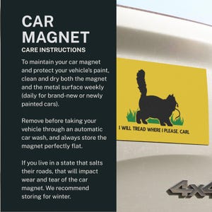 May include: Yellow car magnet featuring a black cat silhouette, green grass, and the text "I WILL TREAD WHERE I PLEASE, CARL." The rectangular magnet is attached to a vehicle.
