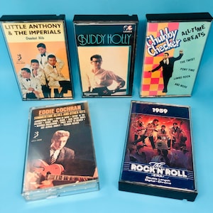 Puede incluir: Una colecci&oacute;n de ocho cintas de cassette vintage con artistas como Little Anthony & The Imperials, Buddy Holly, Chubby Checker y Eddie Cochran. Las cintas est&aacute;n en estuches negros con ilustraciones y texto coloridos.