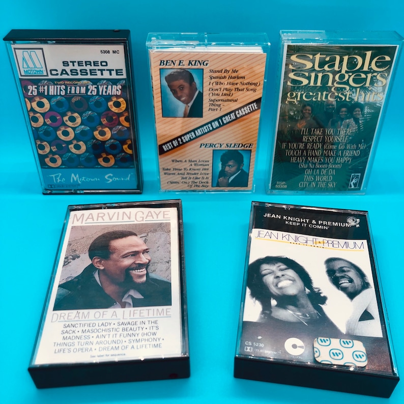 May include: A collection of vintage cassette tapes featuring classic R&B and soul artists. The tapes include albums by Marvin Gaye, Ben E. King, The Staple Singers, and Jean Knight. The cassette cases are clear with colorful album art.