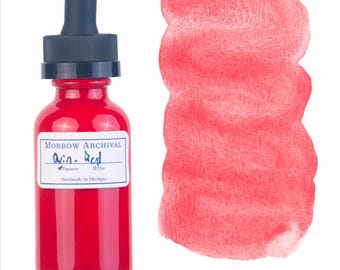 May include: A glass bottle of Quin. Red pigment with a black dropper top, next to a swatch of the same red color. The label reads "Morrow Archival" and "Handmade in Michigan."