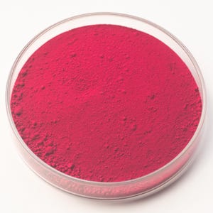 May include: A clear, round petri dish filled with a vibrant, finely ground, red powder. The powder has a slightly textured surface and fills the dish completely. The dish is set against a plain white background.
