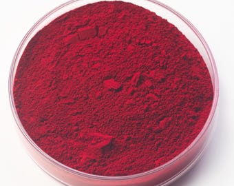 May include: A clear, round petri dish filled with a vibrant red powder. The powder has a fine, granular texture and fills the dish completely. The dish is set against a plain white background.