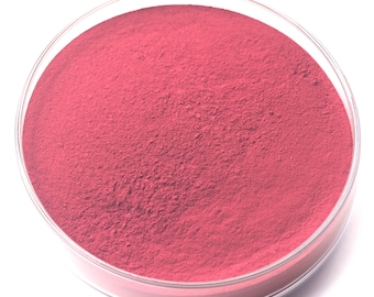 May include: A clear, round petri dish filled with a vibrant, finely ground, pink powder. The powder fills the dish, creating a smooth, even surface. The dish is set against a bright white background.