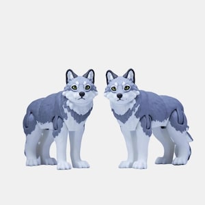 Puede incluir: Dos figuritas de lobo grises y blancas con extremidades articuladas. Los lobos están de pie sobre un fondo blanco.