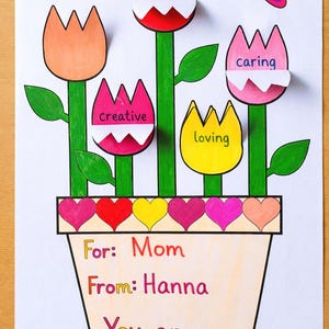 Könnte beinhalten: Handgezeichnete Zeichnung von Blumen in einem Topf, mit einer Biene und einem Schmetterling. Die Blumen haben Etiketten mit den Wörtern "my role model", "creative", "loving" und "caring". Der Text lautet "For: Mom From: Hanna You are..."