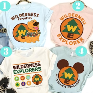 May include: A white ceramic mug with a black handle and the text "But First, Coffee" in a bold, black font. The mug is set against a blurred background, suggesting a cozy setting.